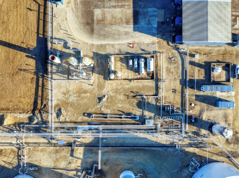 High-altitude shot of a manufacturing plant in Eyota, MN, showcasing industrial structures and pipelines.